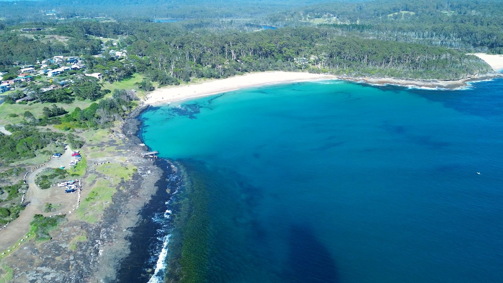 Aerial view of a curved bay and rocky headland at Bawley Point on the NSW South Coast